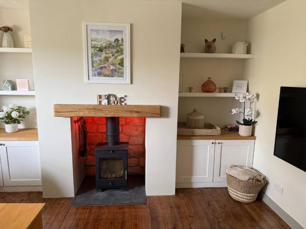 eine Küche mit einem Holzofen im Zimmer in der Unterkunft Maple Cottage in Bourton on the Water