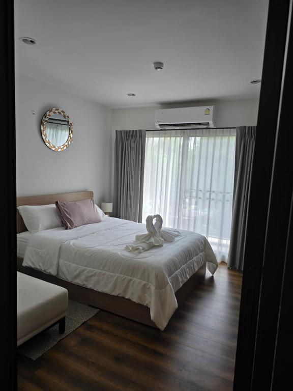 a bedroom with a large bed and a large window at La Habana Huahin by J2A in Hua Hin