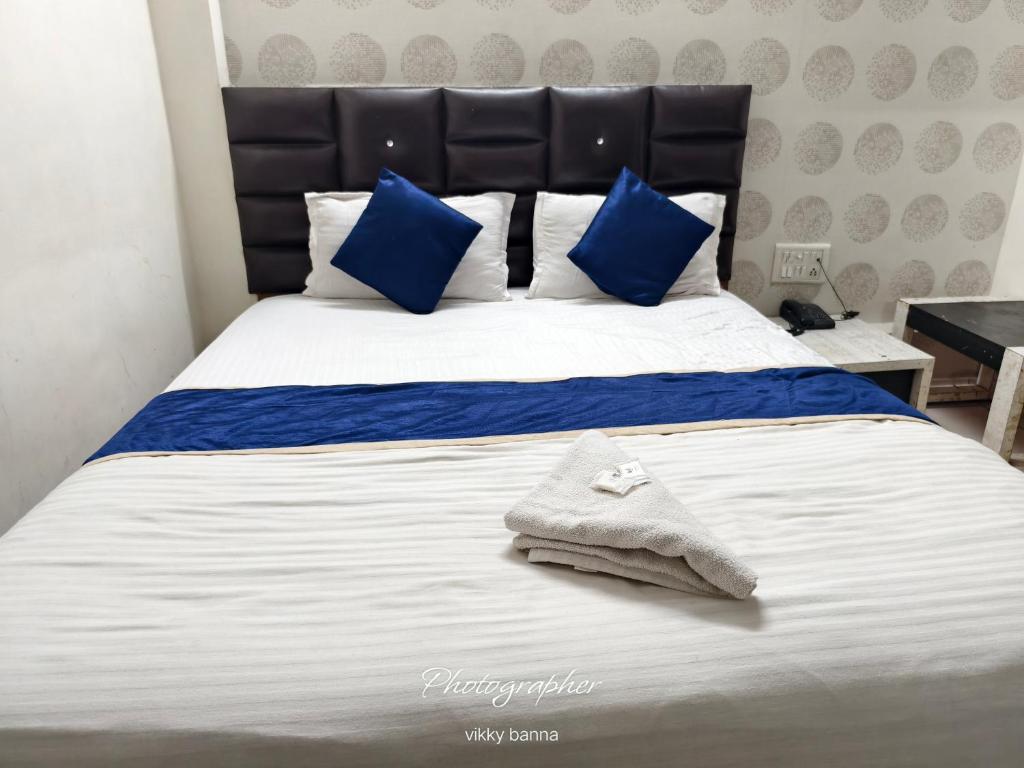 a bed with blue and white sheets and blue pillows at Hotel Sunway in Ahmedabad