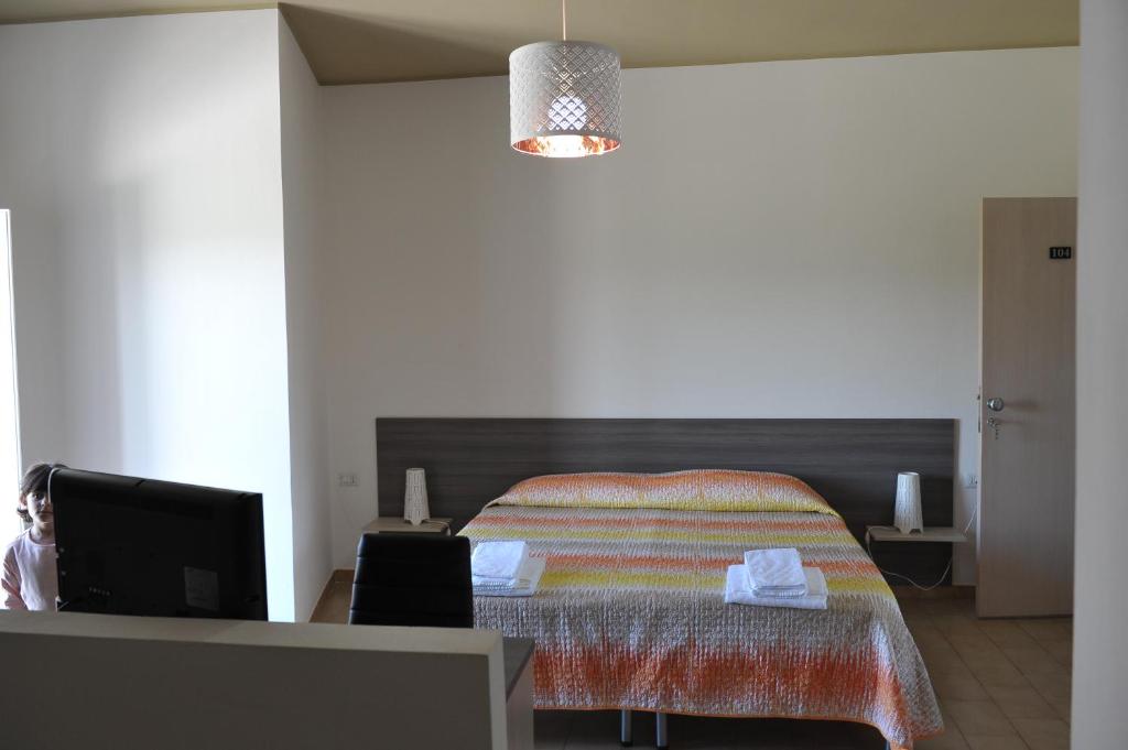 a bedroom with a bed and a desk with a tv at Il Gattopardo in SantʼArcangelo