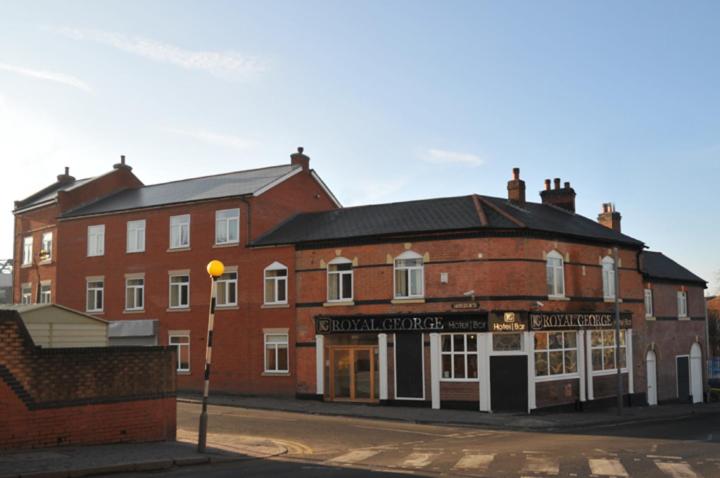 a large red brick building on the corner of a street at Royal George Hotel in Birmingham