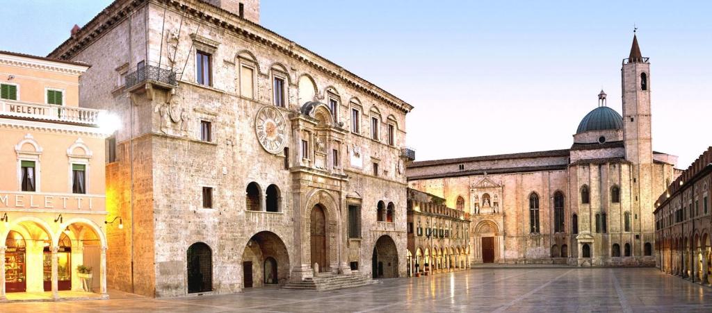 a large building with a clock on the side of it at Ruffini Boutique Rooms in Ascoli Piceno