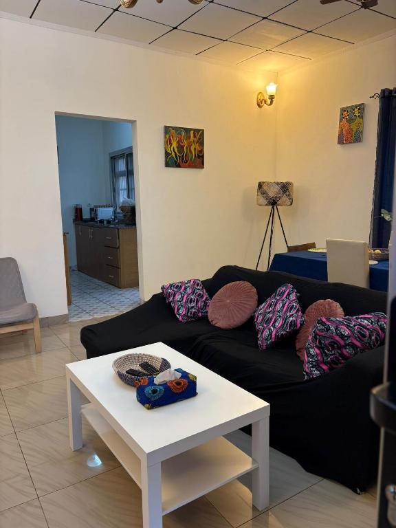 SoumayaVilla Charlotte的客厅里有一张黑色沙发和一张桌子