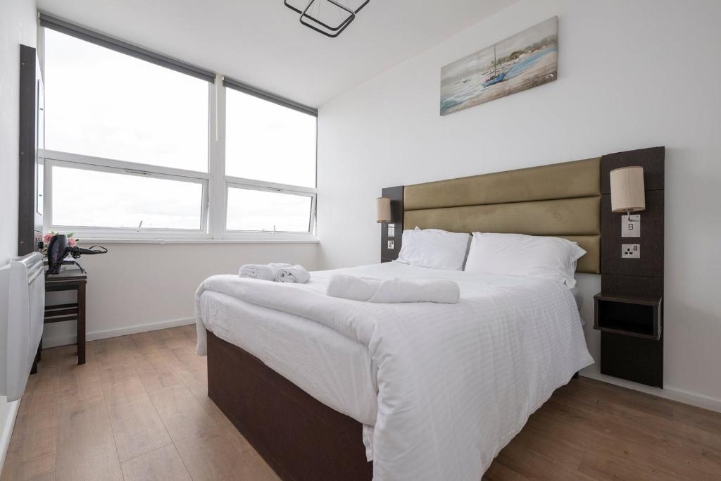 a bedroom with a large bed with a large window at Hawthorns Apartments in Birmingham