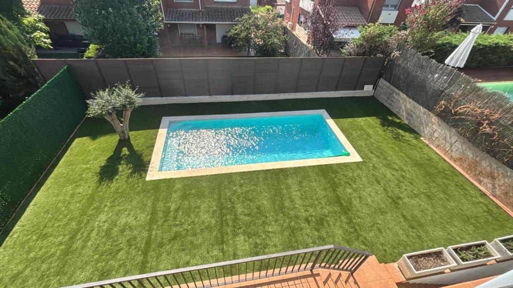 a backyard with a swimming pool and grass at Villa Marta - Girona in Girona