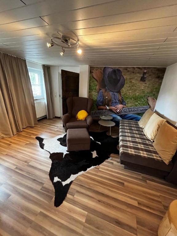 a man sitting on a couch in a living room at Haus Buckaroo – Rancho el Rosal in Bad Mergentheim
