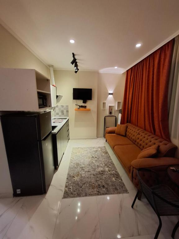 un salon avec un canapé et une cuisine dans l'établissement NBG beach panorama apartment batumi, à Batoumi