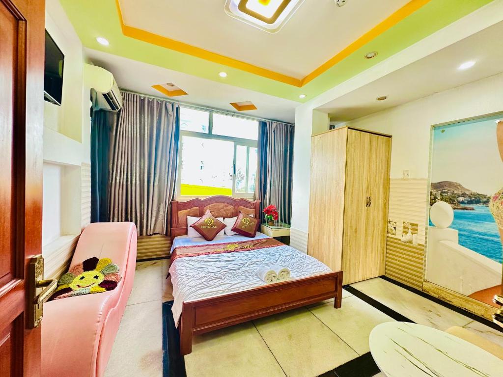 ein Schlafzimmer mit einem Bett und einer Couch und einem Fenster in der Unterkunft Khách sạn VY ANH in Ho-Chi-Minh-Stadt