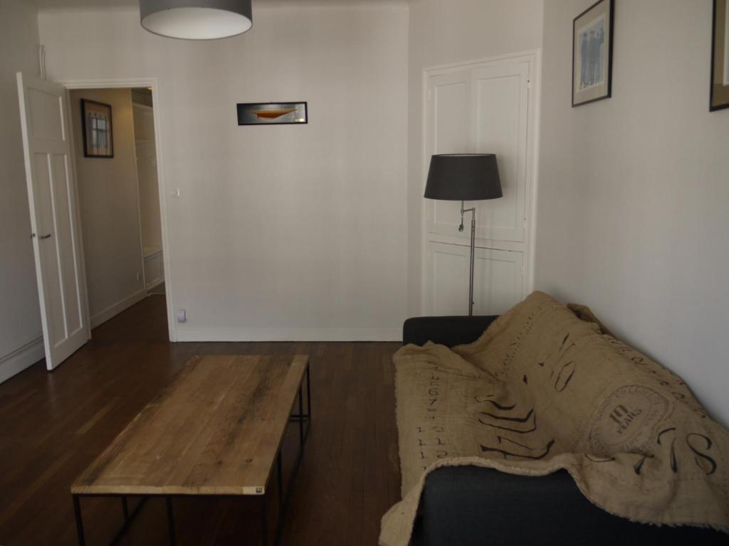 Appartement Chaussee du Sillon في سان مالو: غرفة معيشة مع أريكة وطاولة خشبية