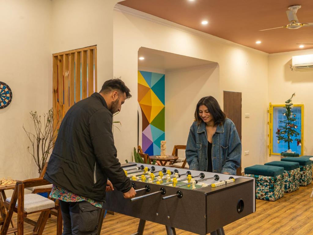 a man and a woman standing next to a giant chessboard at The Hosteller Rishikesh, Upper Tapovan in Rishīkesh