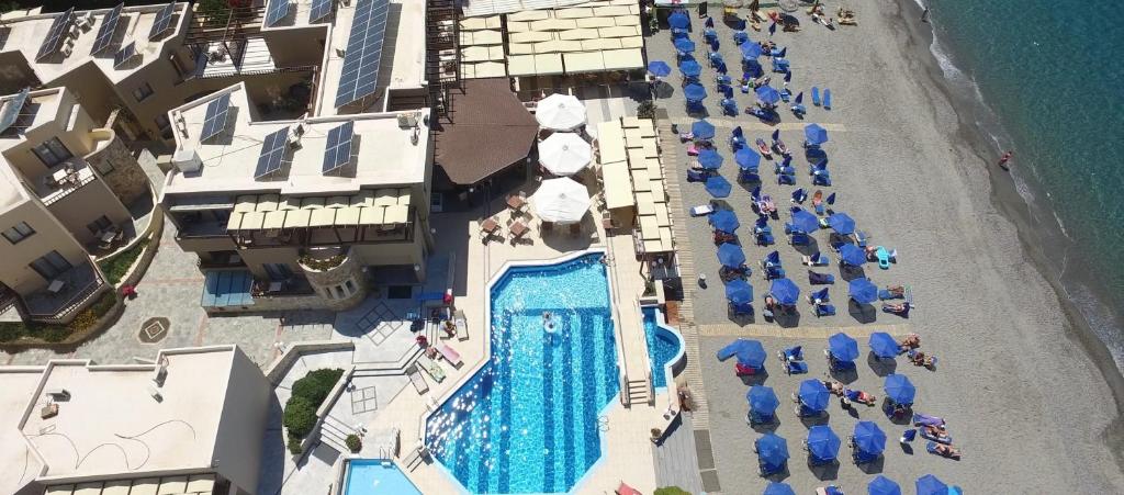 una vista panoramica su una spiaggia con ombrelloni e piscina di Indigo Mare a Plataniás