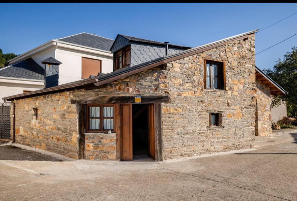 a stone building with a large door in front at VUT La casita del Pajar in Vega de Espinareda