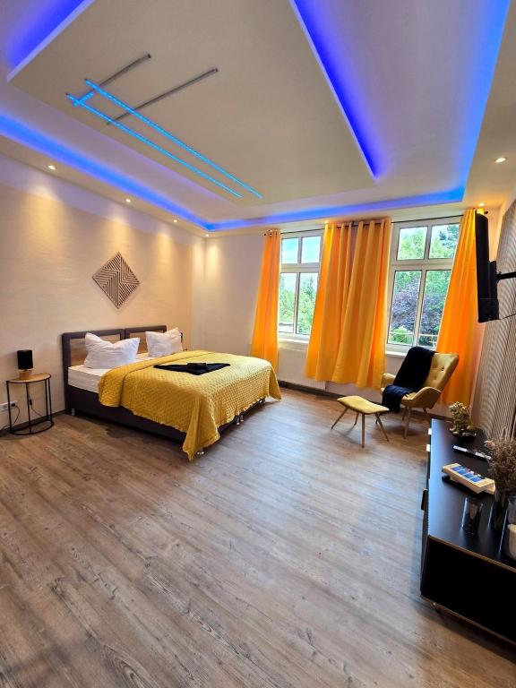 a bedroom with a bed and a couch and windows at Stilvoll zu Hause mit Charme, bis zu 7 Personen in Halberstadt