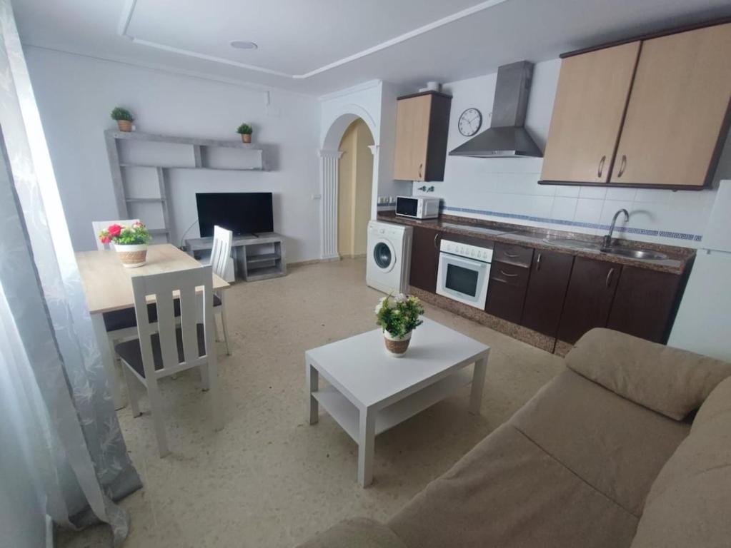サンルーカル・デ・バラメダにあるApartamento Plaza Altaのソファとテーブルのあるキッチンとリビングルーム