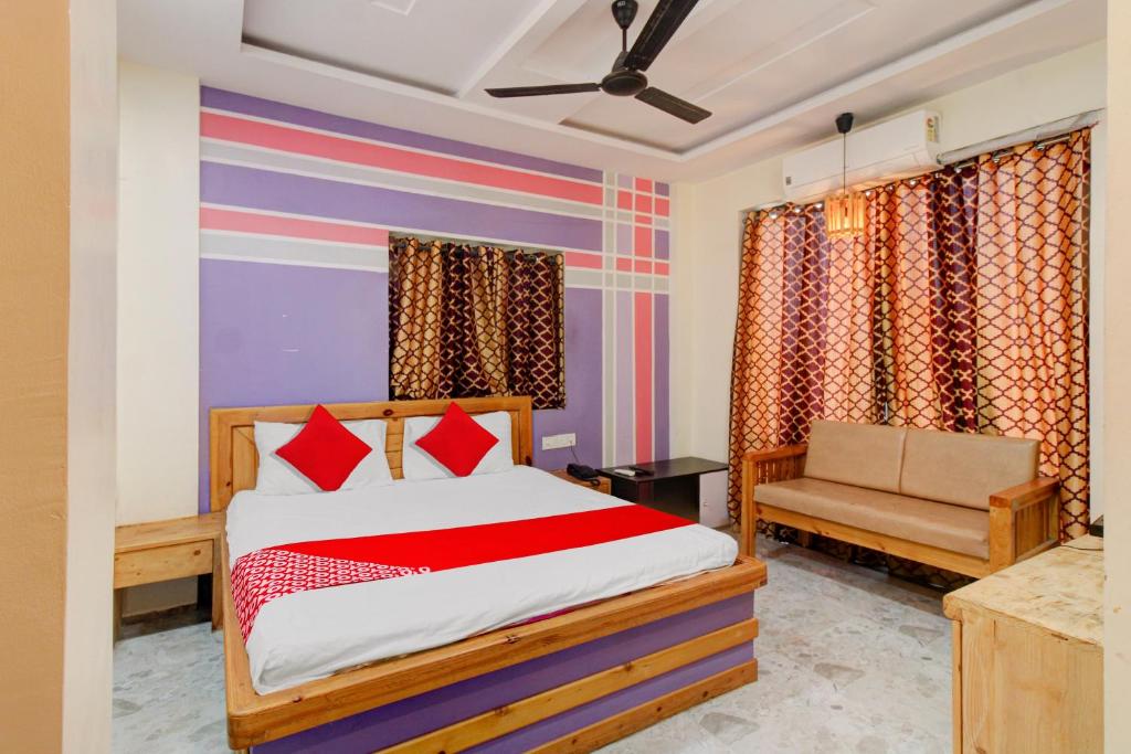 a bedroom with a bed and a couch in it at Hotel O Holiday Prime in Nagpur