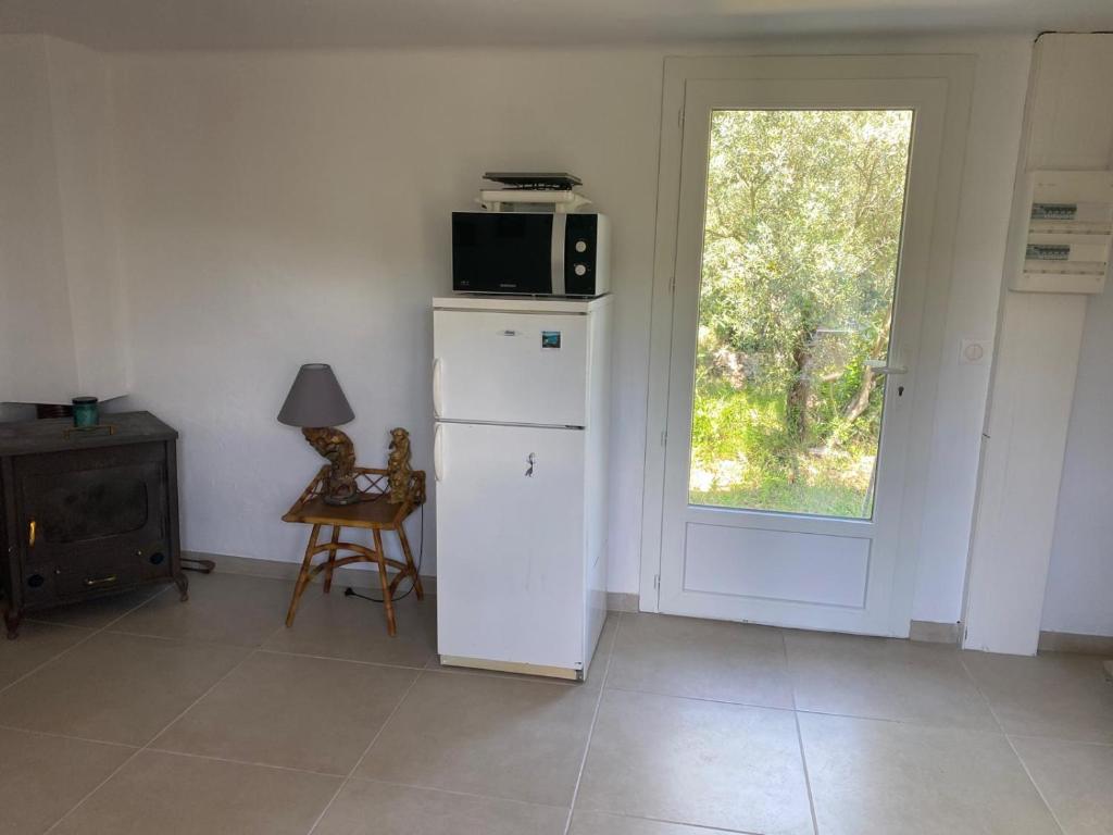 a kitchen with a microwave on top of a refrigerator at Au coeur de l'oliveraie in Draguignan