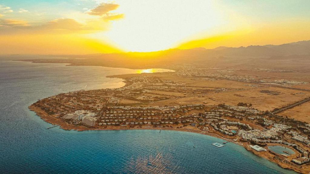 eine Luftansicht einer Stadt mit Sonnenuntergang in der Unterkunft Stanza Luna, Domina Coral Bay, Prestige hotel in Sharm El Sheikh