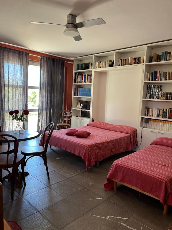 1 dormitorio con 2 camas, mesa y estanterías en Colonica Il Picchio Verde, en Altopascio