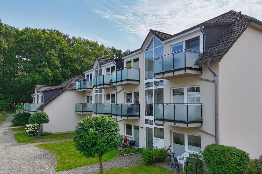 an apartment building with balconies and a yard at Apartmentanlage Eldena Ferienwohnung 10 in Lobbe