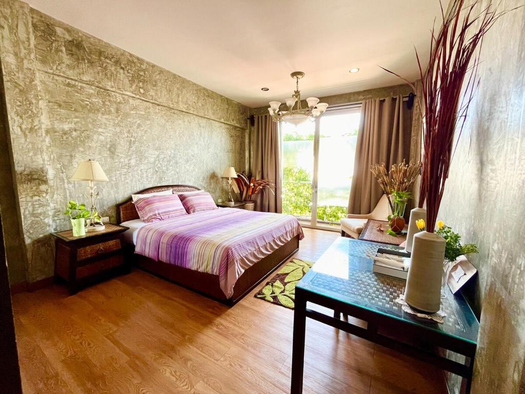 une chambre avec un lit, une table et une fenêtre dans l'établissement WiNNiNE Cozy Home, à Bangkok