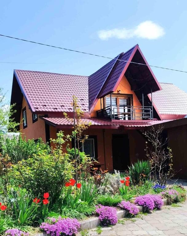 une maison avec un jardin fleuri devant elle dans l'établissement Затишок Карпат, à Vygoda