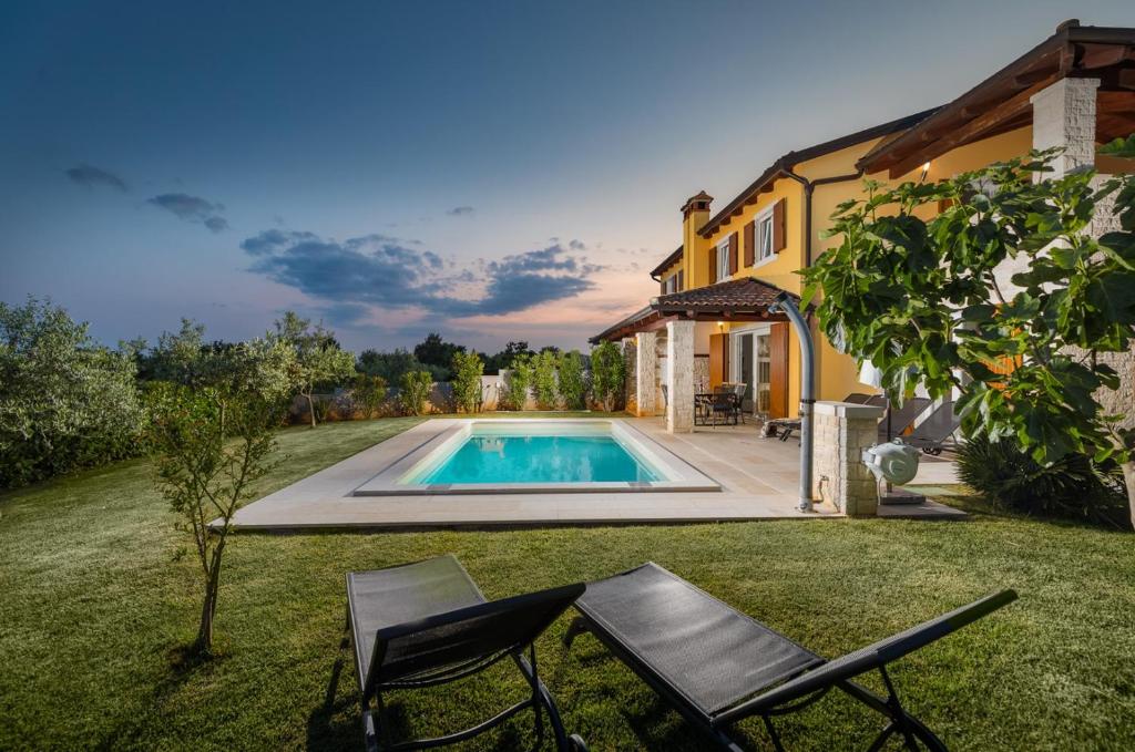 a backyard with a swimming pool and a house at Villa Katharina in Krmenjak
