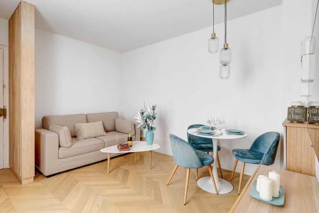 a living room with a couch and a table and chairs at 606 Aaron Suite - Apartment in Paris 7th in Paris