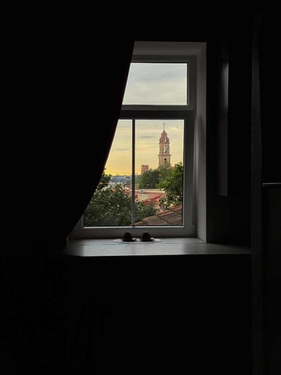 ein offenes Fenster mit Blick auf ein Gebäude in der Unterkunft Jacuzzi overlooking the tower in Vilnius