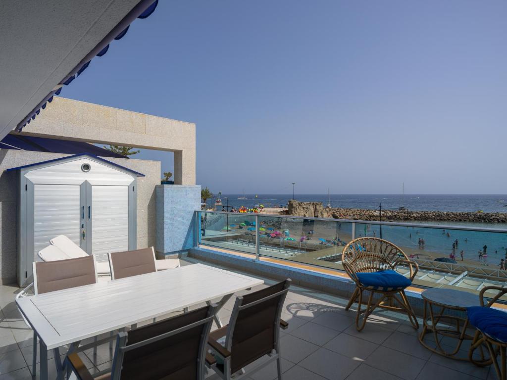 a balcony with a table and chairs and a view of the beach at Blue Horizon Mogan in Puerto de Mogán