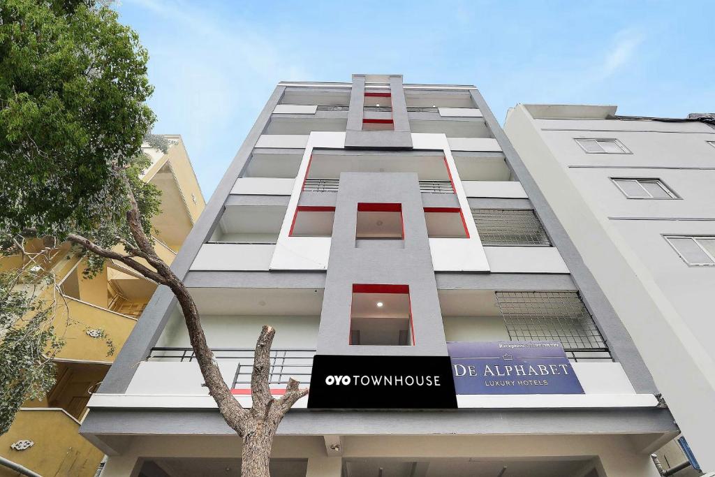 un grand bâtiment blanc avec une enseigne dessus dans l'établissement Super Townhouse De Alphabet Kukatpally Near Nexus Mall, à Hyderabad