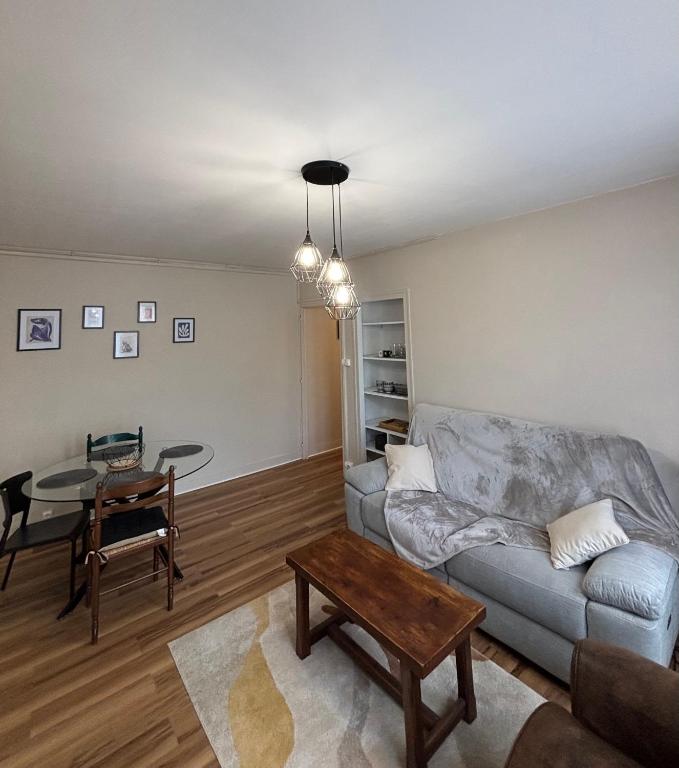 a living room with a couch and a table at T2 Rénové, centre, parking privé in Limoges