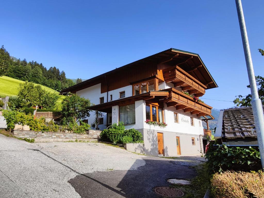 a house with a wooden roof on a street at Haus Elisabeth in Hainzenberg