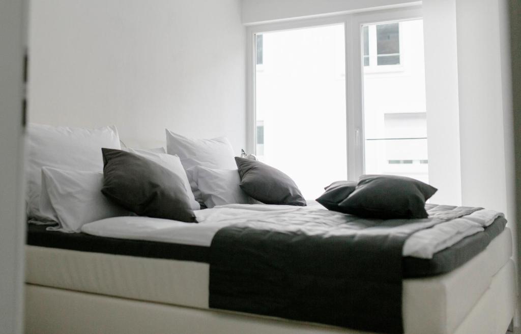 uma cama com almofadas num quarto em Stadthaus Regensburg em Regensburg