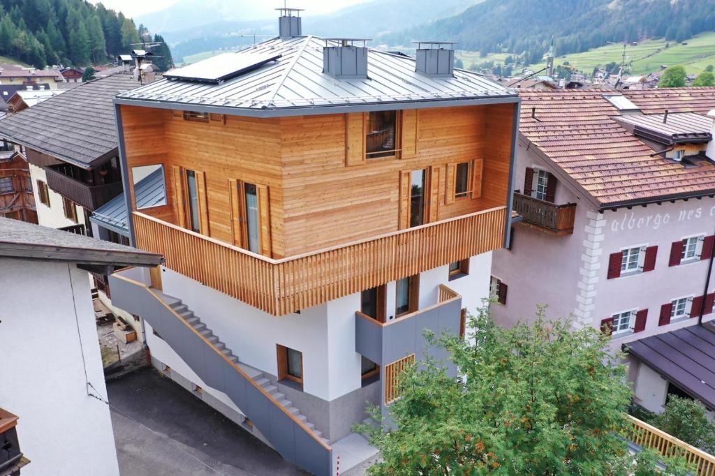 una casa di legno con un tetto di metallo su un edificio di Ciasa Nü - Piano Rialzato a Pozza di Fassa