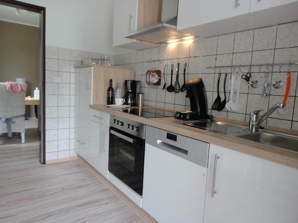 a kitchen with white cabinets and a sink and a stove at Ferienwohnung Antel in Andernach