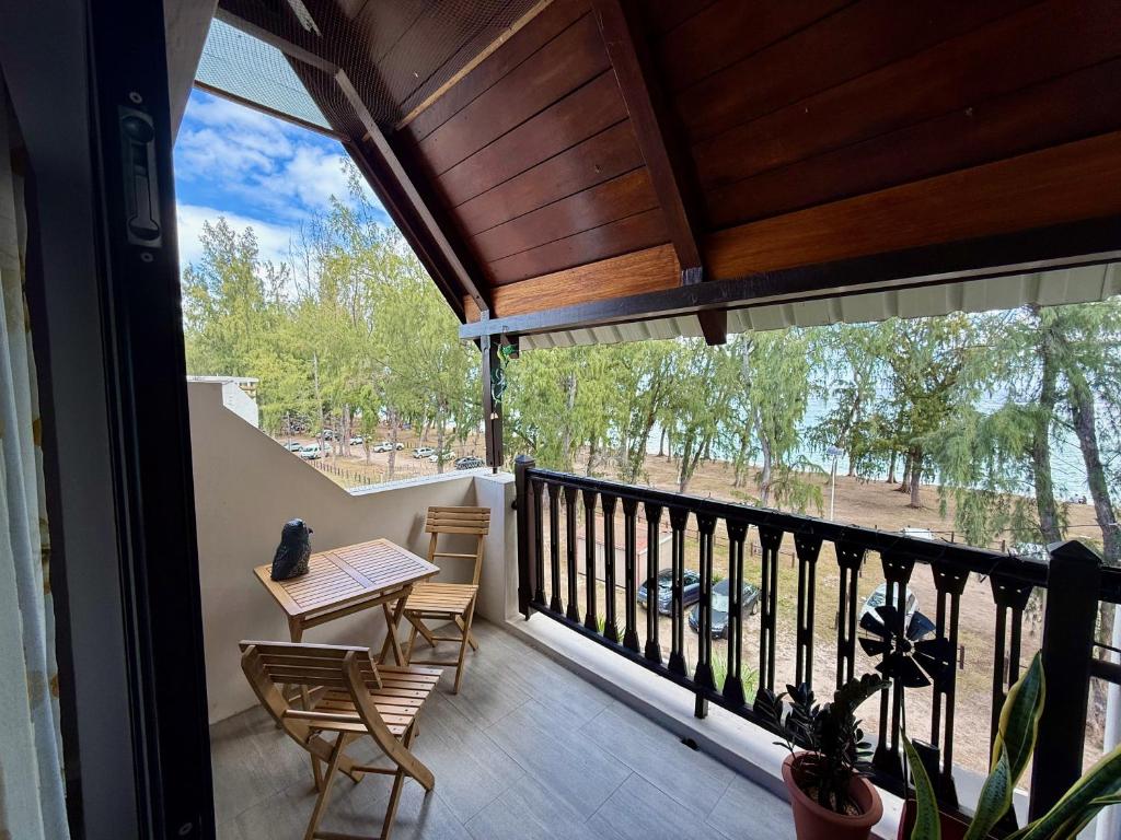 een veranda met een tafel en stoelen op een balkon bij Caz la plaz - Beach front apartment - 2BR in Flic-en-Flac