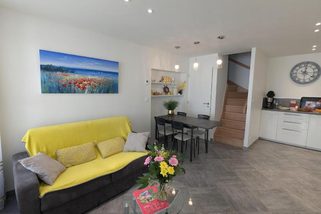 a living room with a yellow couch and a table at Magnificent house of 54 m2 2 steps from the beach in Les Sables-dʼOlonne