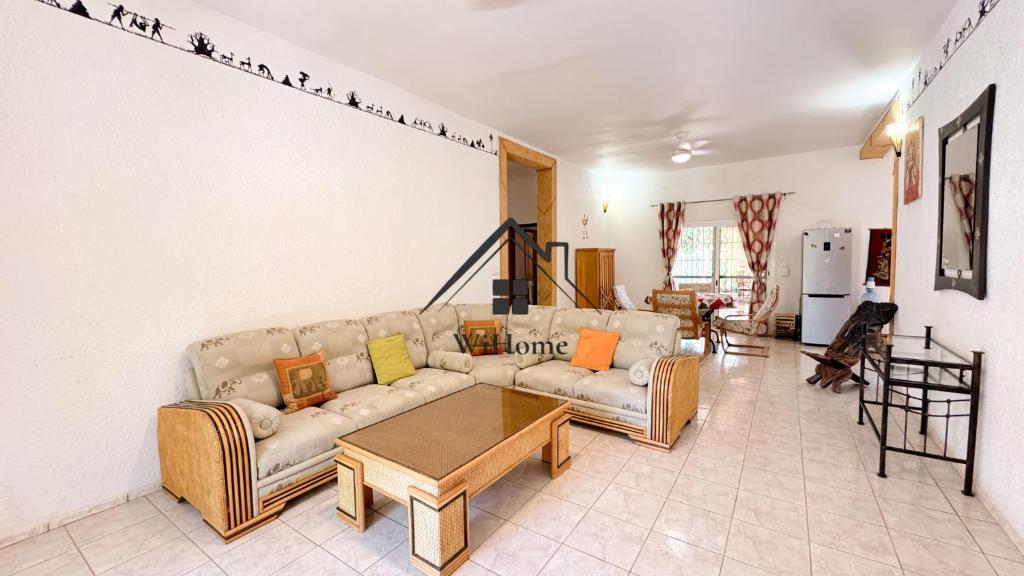 a living room with a couch and a table at Villa Gallé Kouley bord de mer in Somone