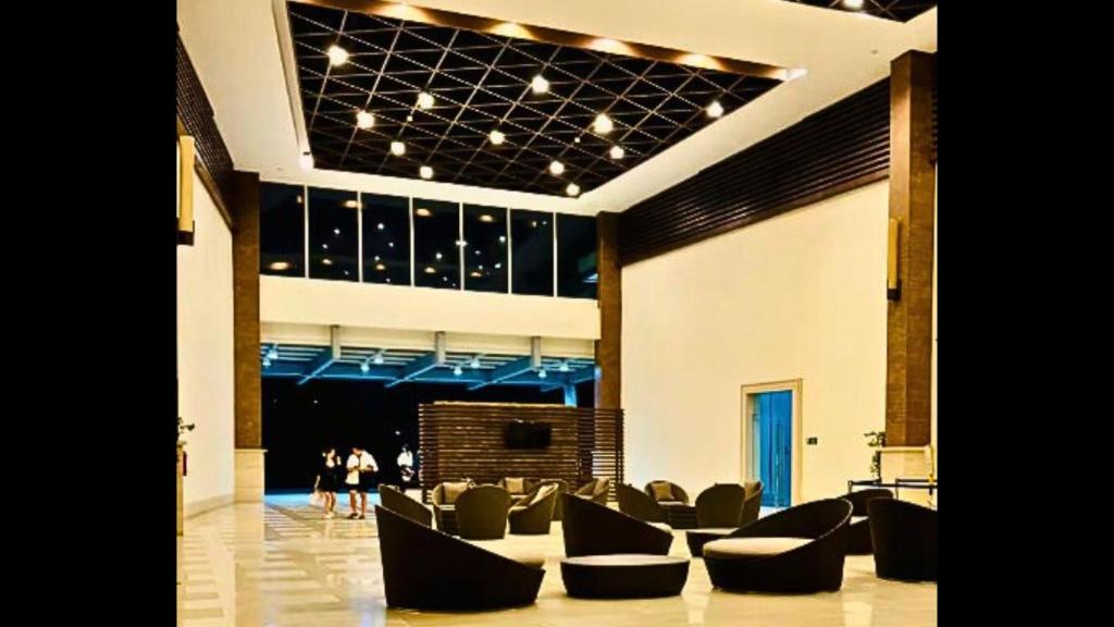 um lobby com sofás e pessoas caminhando ao fundo em Need Place To Stay Wake Up to Breathtaking Taal Views from Your Window I Tagaytay Getaway em Kaybagal