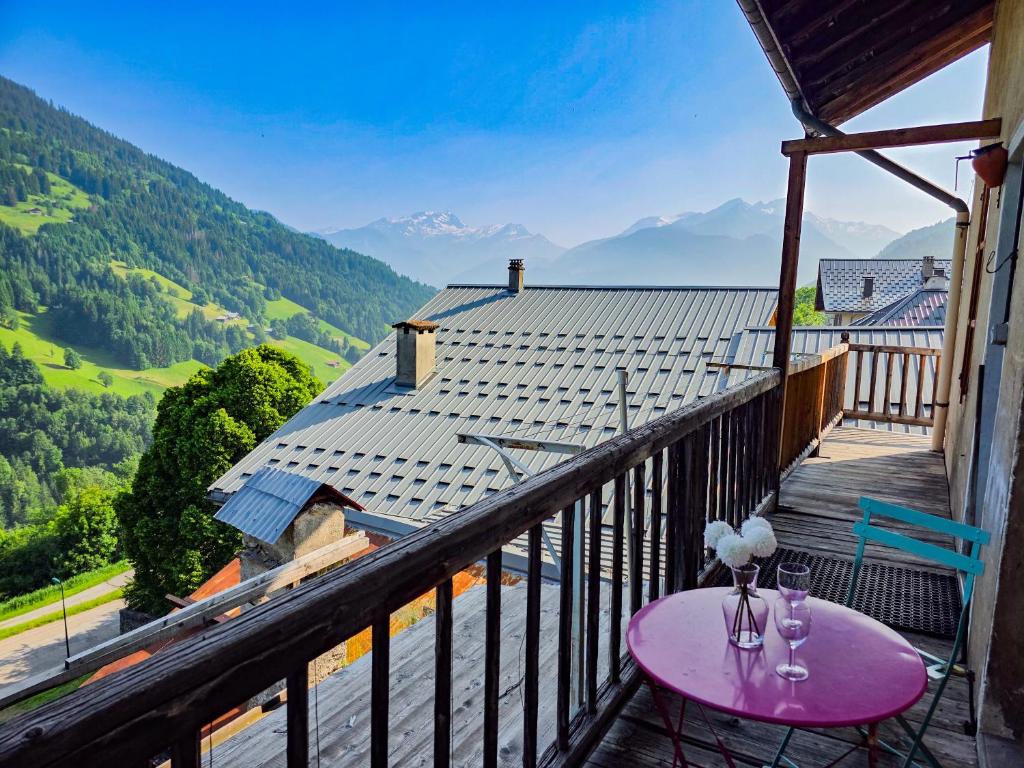 a table on a balcony with a view of mountains at Le Nid D'Hauteluce - Proche centre ville in Hauteluce