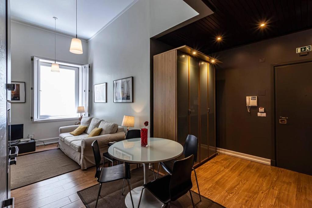 a living room with a table and a couch at Well-Located Studio with Smart Space in Lisbon