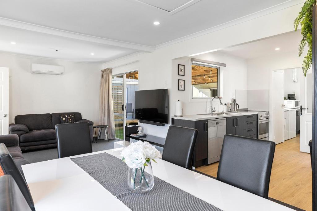 eine Küche und ein Wohnzimmer mit Tisch und Stühlen in der Unterkunft Large Family Lakehouse in Mangakino