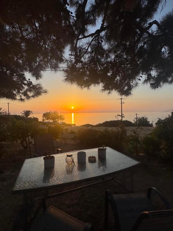 a table with three pots on it with a sunset in the background at Remvi Apartments in Armenistis