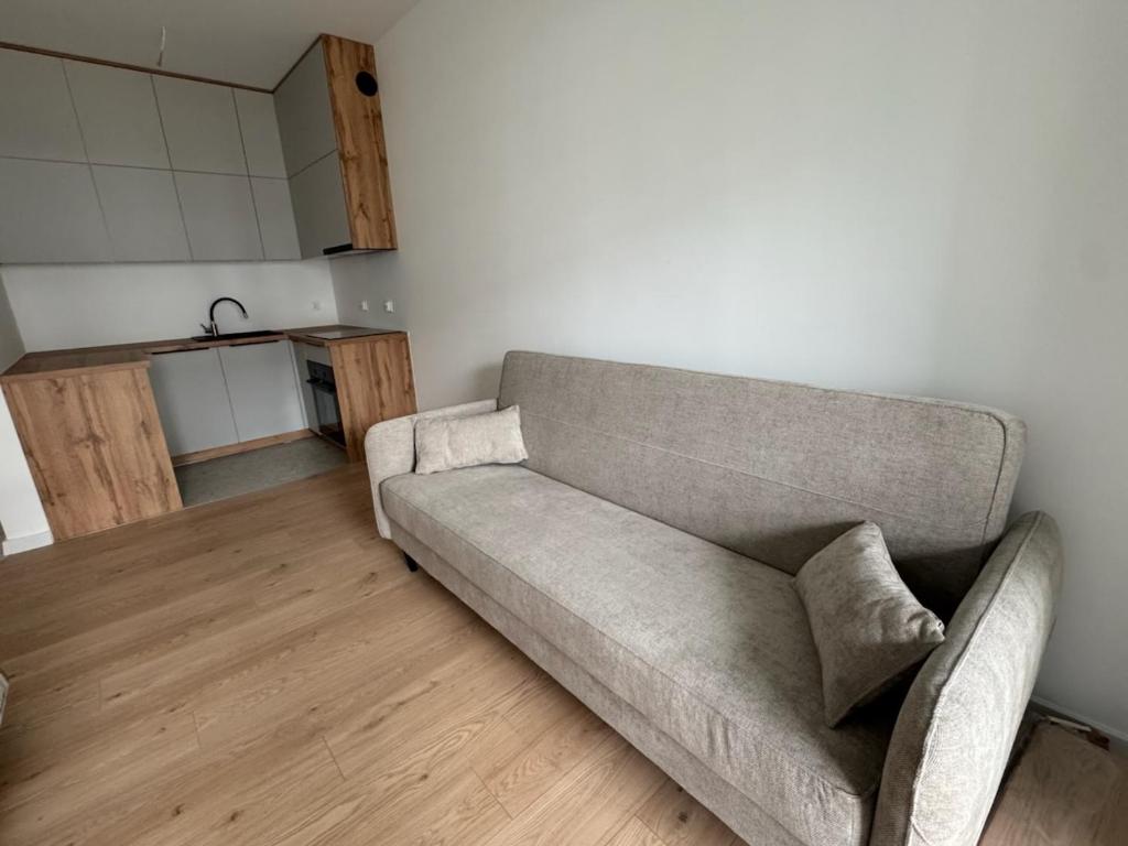 a living room with a couch and a kitchen at Apartament 