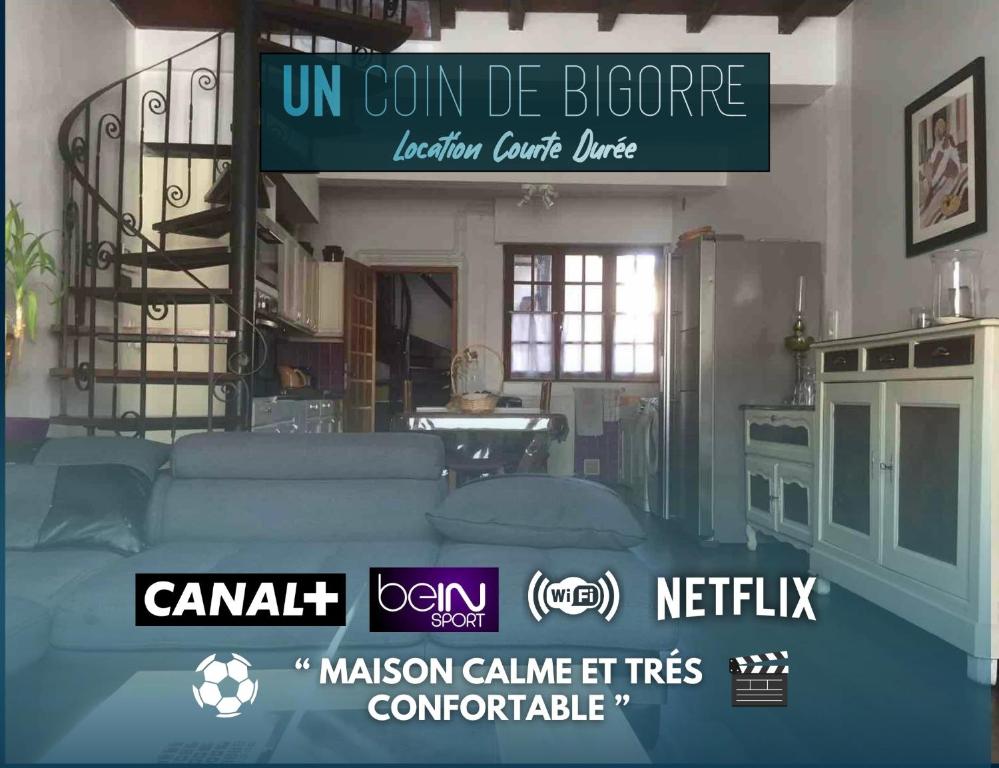un soggiorno con divano blu e un cartello di Logements Un Coin de Bigorre - La Tournayaise - Canal plus, Netflix, Bein, Apple TV - Wifi Fibre a Tournay