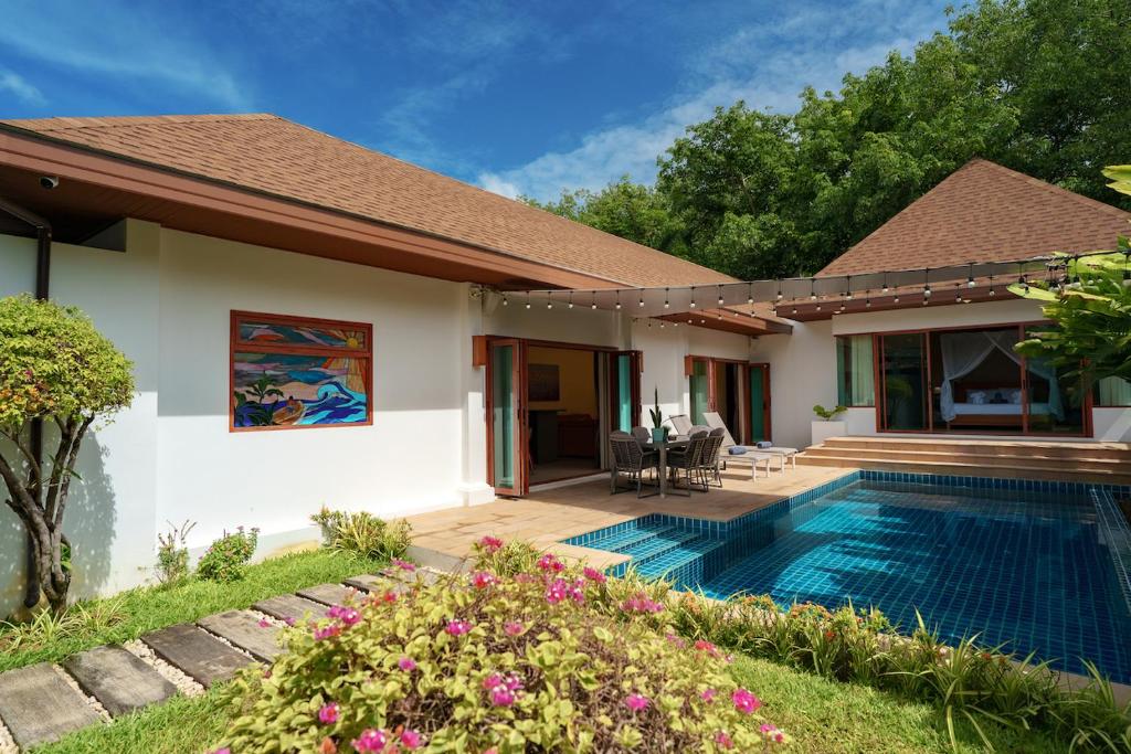 a villa with a swimming pool and a house at Blue Moon by G Estate Phuket in Ban Saiyuan (1)
