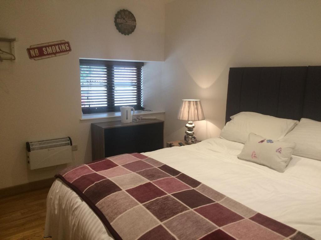 a bedroom with a large bed and a window at The Radnor Arms in Malmesbury
