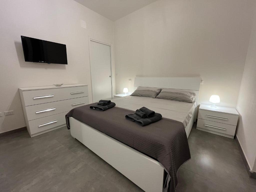 una camera da letto con un letto, una cassettiera e una televisione di La casetta della piazza a Carovigno