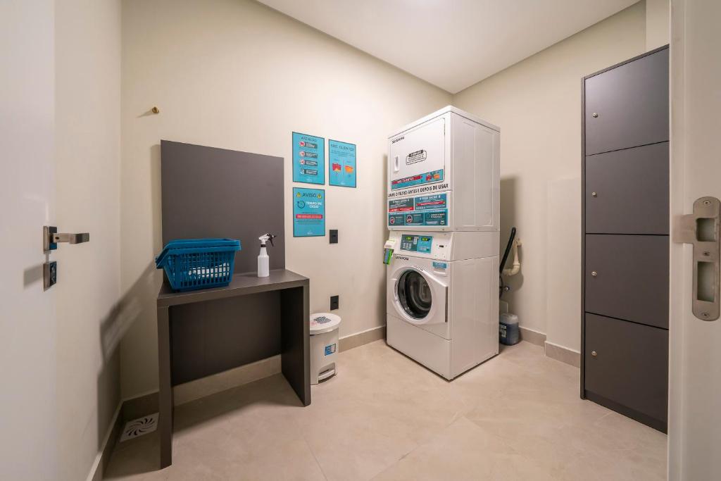 a laundry room with a washing machine and a desk at Apartamento 509 com piscina Aquecida in Bombinhas