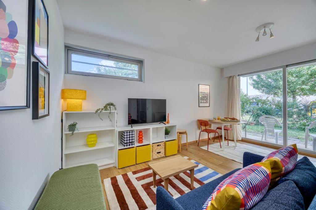 un salon avec un canapé bleu et une table dans l'établissement Garden & Central - Near United Nation - Geneva - CERN, à Ferney-Voltaire